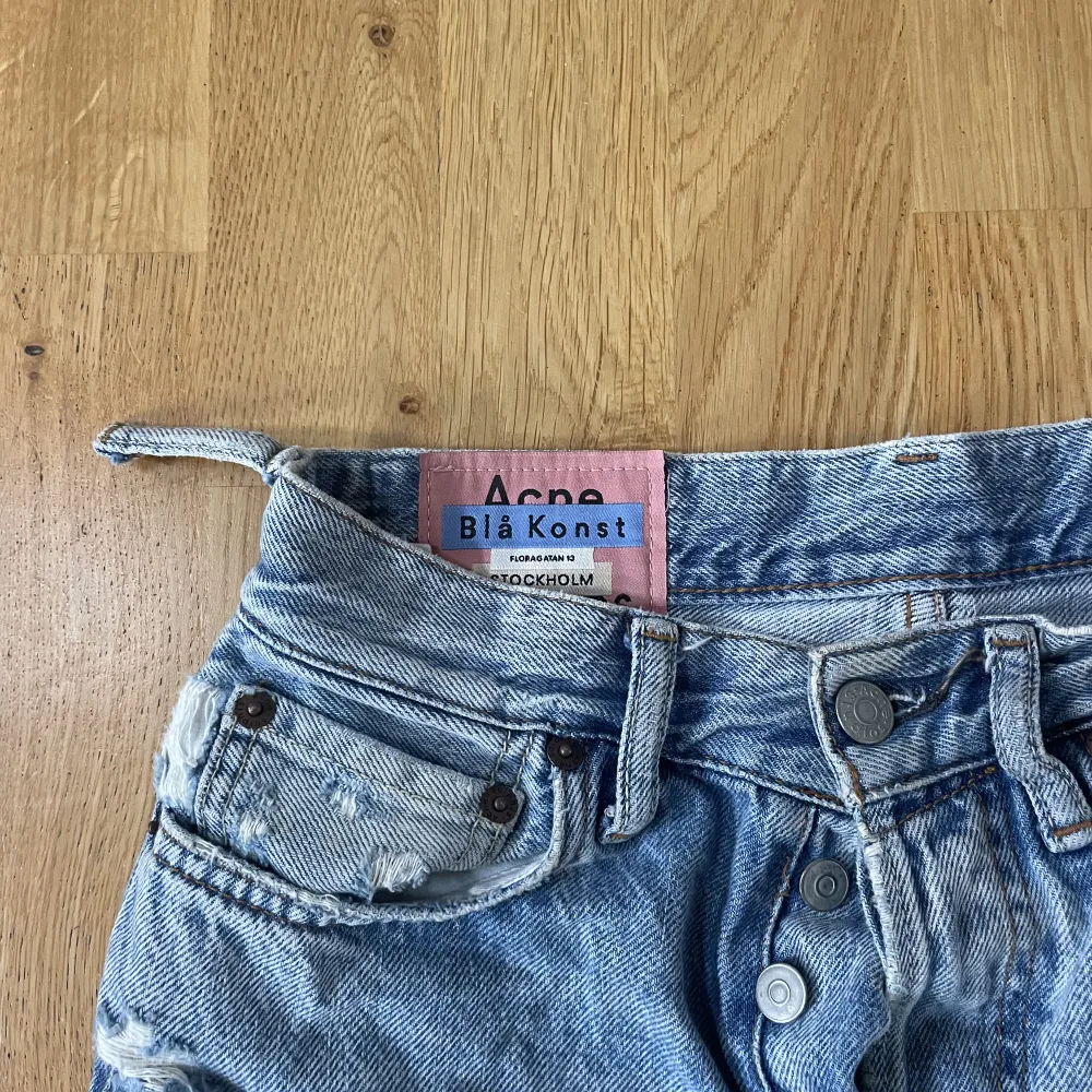 Ett par blåa snygga jeans från Acne. Jeansen är använda mycket och därför urtvättade och söndriga på ett ställe (syns på bild 2). Storlek  26/32, 165/66A. . Jeans & Byxor.