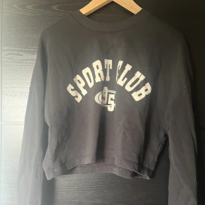 Sweatshirt  - Mörkgrå/svart sweatshirt med tryck från Gina.