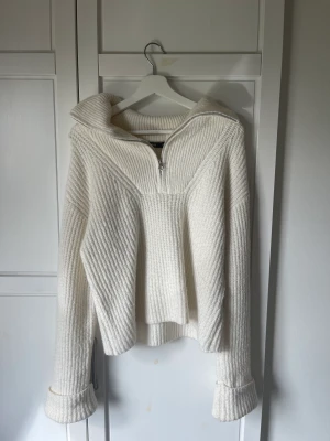 Stickad tröja med dragkedja  - Vit stickad tröja med dragkedja från bikbok. Använd ett fåtal gånger. Rejält material och långa armar.