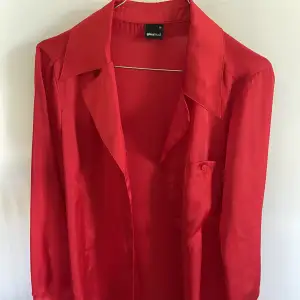 Röd satin-skjorta i nyskick, superfin både till vardags och som nattplagg. 