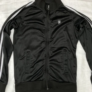 Svart ”adidas” jacka - Svart ”adidas” jacka. Står storlek 158/164, men skulle säga att den passar en xs-s. Lite sliten på dragkedje spännet.