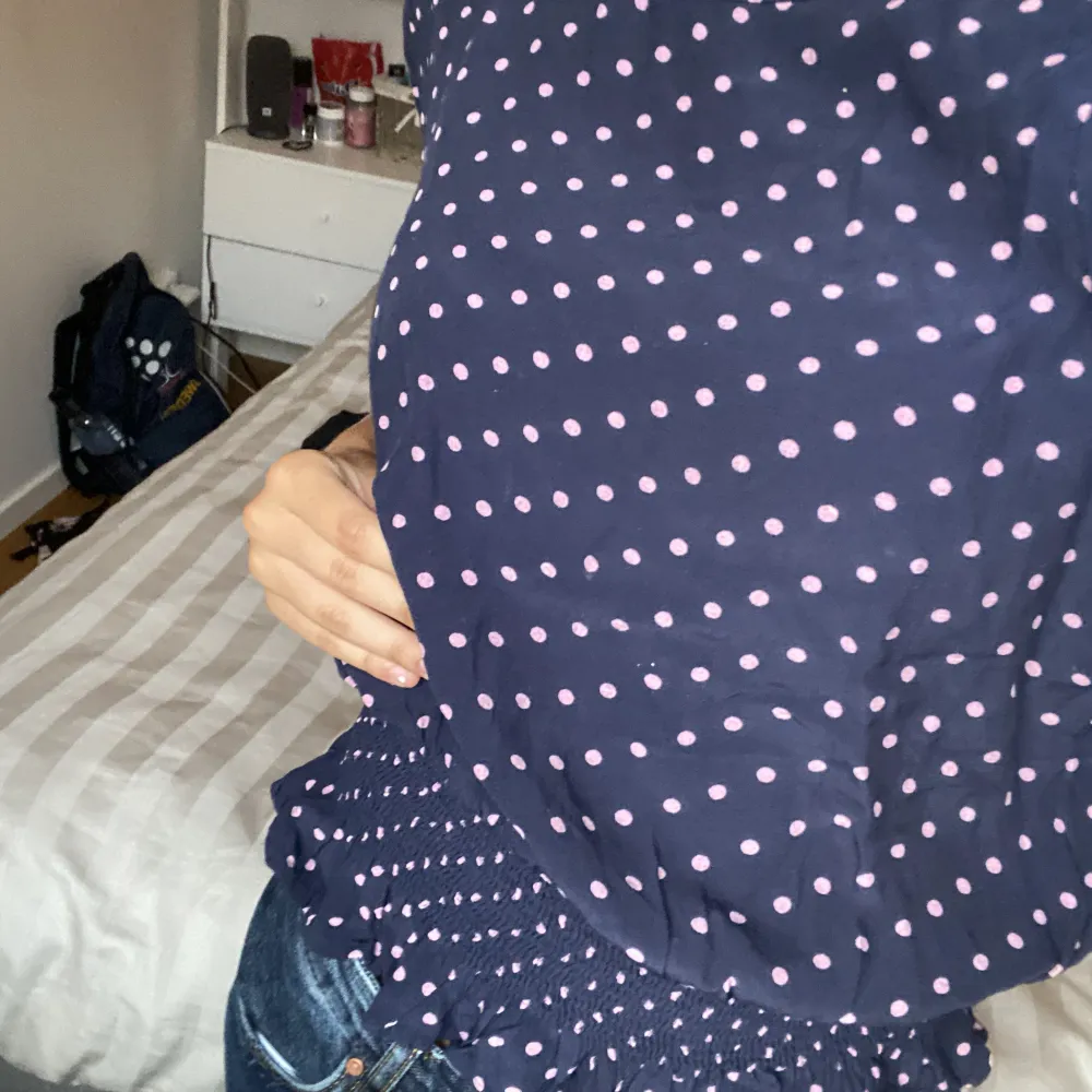 Marinblå blus med ljuslila prickar. Som man kan se tydligt på första bilden så är det ”scrunch” vid midjan vilket gör att den går in mot kroppen där. Ursäkta dåligt ljus på sista bilden! Pris går att diskuteras! Skriv privat för fler bilder! 😊. Puserot.