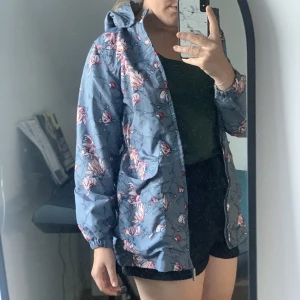 Regnjacka - Blommig regnjacka, använd 1 gång. Säljer pga för liten på mig. 🌻Storleken passar barn i 10-12 åldern så hej hej till alla mammor där ute 👋