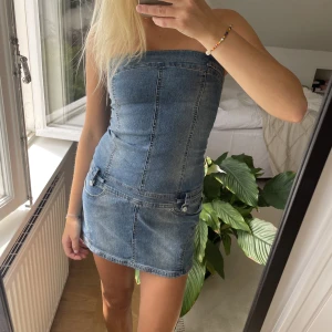 Jeansklänning  - En unik jeansklänning köpt secondhand med coola detaljer!💗