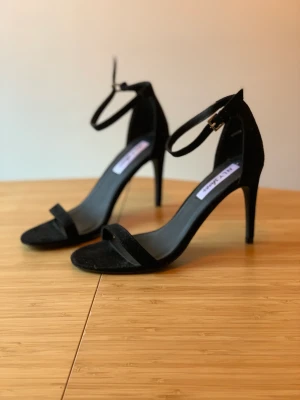 Oanvända svarta klackar/sandaletter strl 38 - Säljer dessa oanvända stilrena svarta klackar/sandaletter från Nelly i strl 38. Materialet är sammet. Klacken är ca 7 cm hög. Säljer pga använder ej klackskor tyvärr, men köpte dem pga tyckte de var så fina.