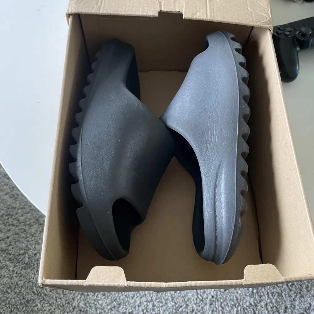 Yeezy slides i storlek 44,5. Bra skick, skriv för mer bilder! Skulle säga att dem passar 43-44. Box medföljer och äkta såklart . Skor.