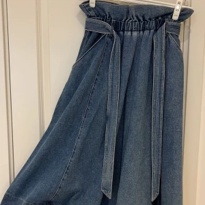 Jeans kjol - H&M - Jättefin jeans kjol från H&M i storlek S. Den har två fickor på framsidan samt ett bälte i jeans material. Den är lagom lång, jag är 160 cm och den var liiite under mina vader. Har använt den 5-6 gånger, ser exakt ut som ny. Det är äkta jeans material!!