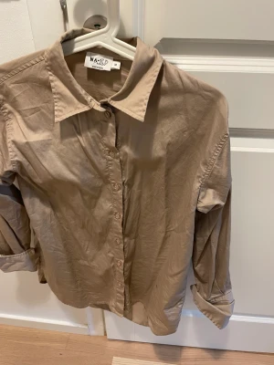 Beige skjorta - Oversized skjorta från nakd. Storlek 32, passar en xxs-s! Använd en gång.