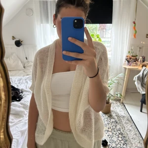 Stickad kofta - SUPERSÖT kortärmad stickad kofta!! Jättesnygg detalj över outfiten. Köpt secondhand men ser inte sliten ut. Har dock ett litet hål som syns på första bilden (högra axeln). 🥰