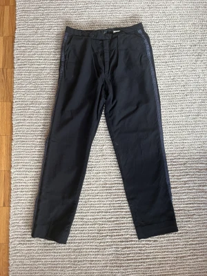 Kostymbyxor  - Svarta kostymbyxor med snygg detalj på sidan. Står ingen storlek men passar mig som vanligtvis har M/38.