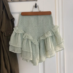 Volangkjol - Söt ljusgrön volangkjol. Finns inte att köpa i butik. Köpt för 300kr, helt oanvänd på grund av passformen. Kan även användas som en söt ärmlös topp :) 💕💕