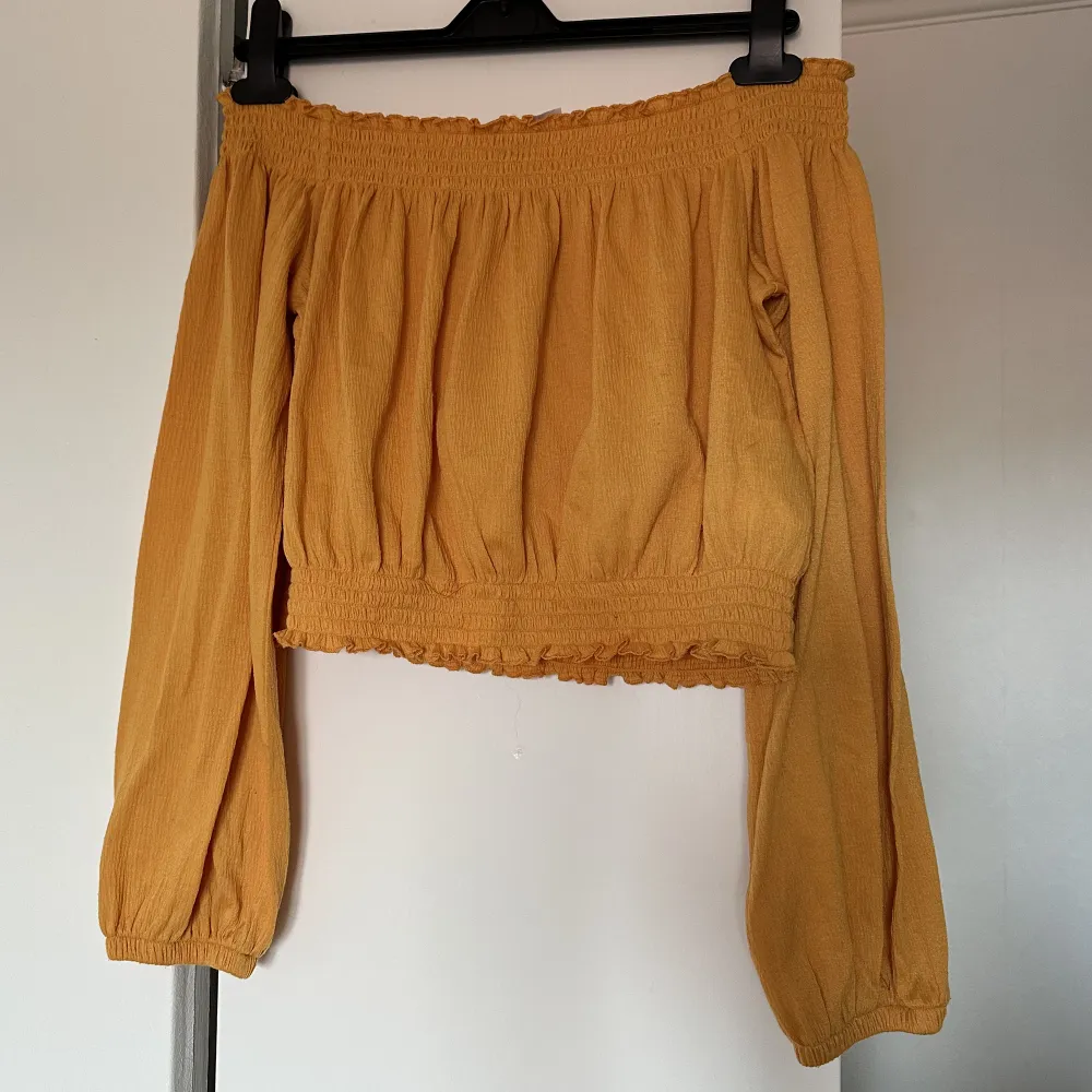 Gul/orange off shoulder tröja från h&m i jätte fint skick då knappt använd 💛🧡. Toppar.