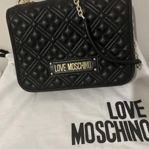 Love Moschino väska - Säljer nu min fina svarta Love Moschino väska som tyvärr inte kommer till anändning. Köpt på Zalando för 2500kr o säljer nu för 1500kr. I nytt skick använd endast fåtal gånger.