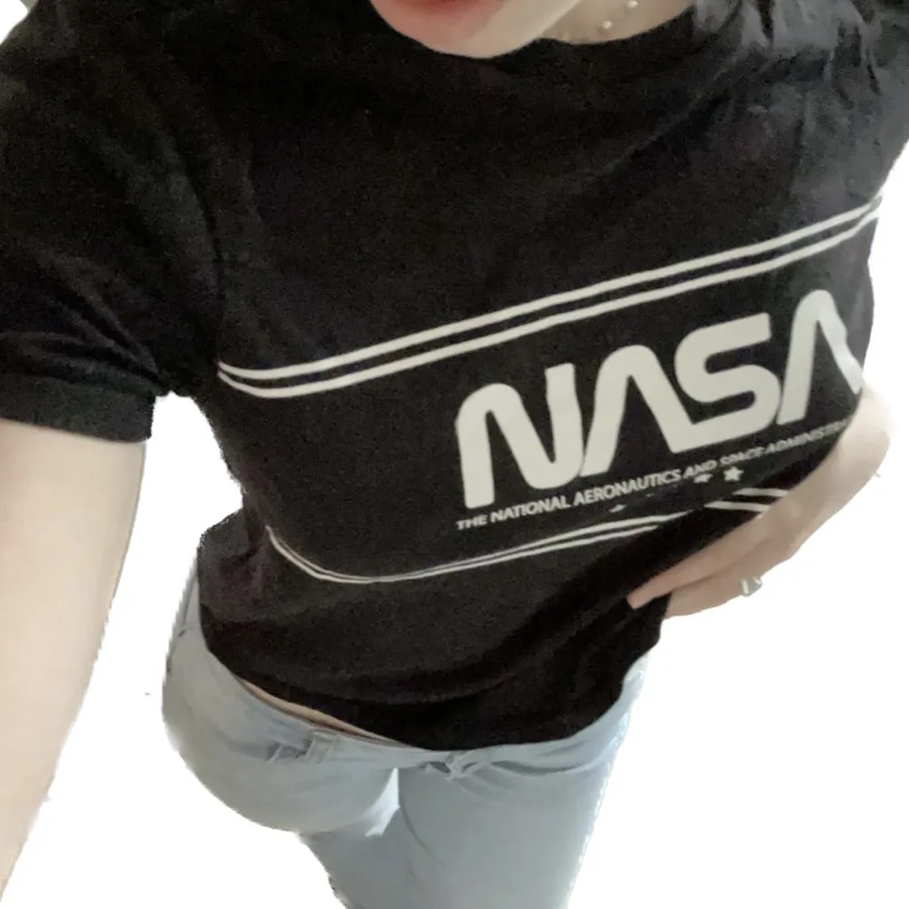 En svart T-shirt med NASA tryck i nyskick, Knappt använd förrutom för att ta dessa bilder då det inte är min stil. Ställ gärna frågor🩵. Toppar.