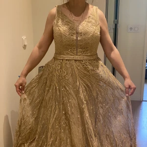 Guldig festklänning💗 - En jätte fin och elegant klänning köpt utomlands, Dubai. Den är  oanvänd med lappen kvar. Nypris är 4000kr, jag säljer den då för 3500 eftersom den är i nyskick.Köpare ansvarar för fraktkostnaden men annars kan jag mötas upp i stockholm❤️❤️