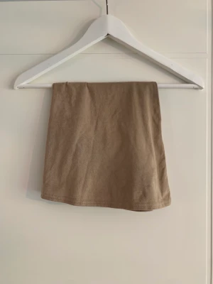 Beige kjol - Beige ’mocka’ kjol från Nelly. Tunt material och väldigt lätt. Resorband i midjan. 