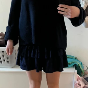 Mörkblå volangkjol (shorts) - Supersöt mörkblå volang”kjol” som egentligen är shorts (den ser alltså ut som en kjol på). Den är perfekt när du vill vara bekväm och inte vill att den åker upp så fort det blåser. Jättefin sommar underdel!