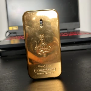 1 Million Eau de Toilette från Paco Rabanne 50 ml - 1 Million från Paco Rabanne är en ikonisk herrparfym i en lyxig guldfärgad flaska som liknar en guldtacka. Flaskan rymmer 50 ml och har en stilren, rektangulär form med metallisk finish och präglad logotyp framtill.