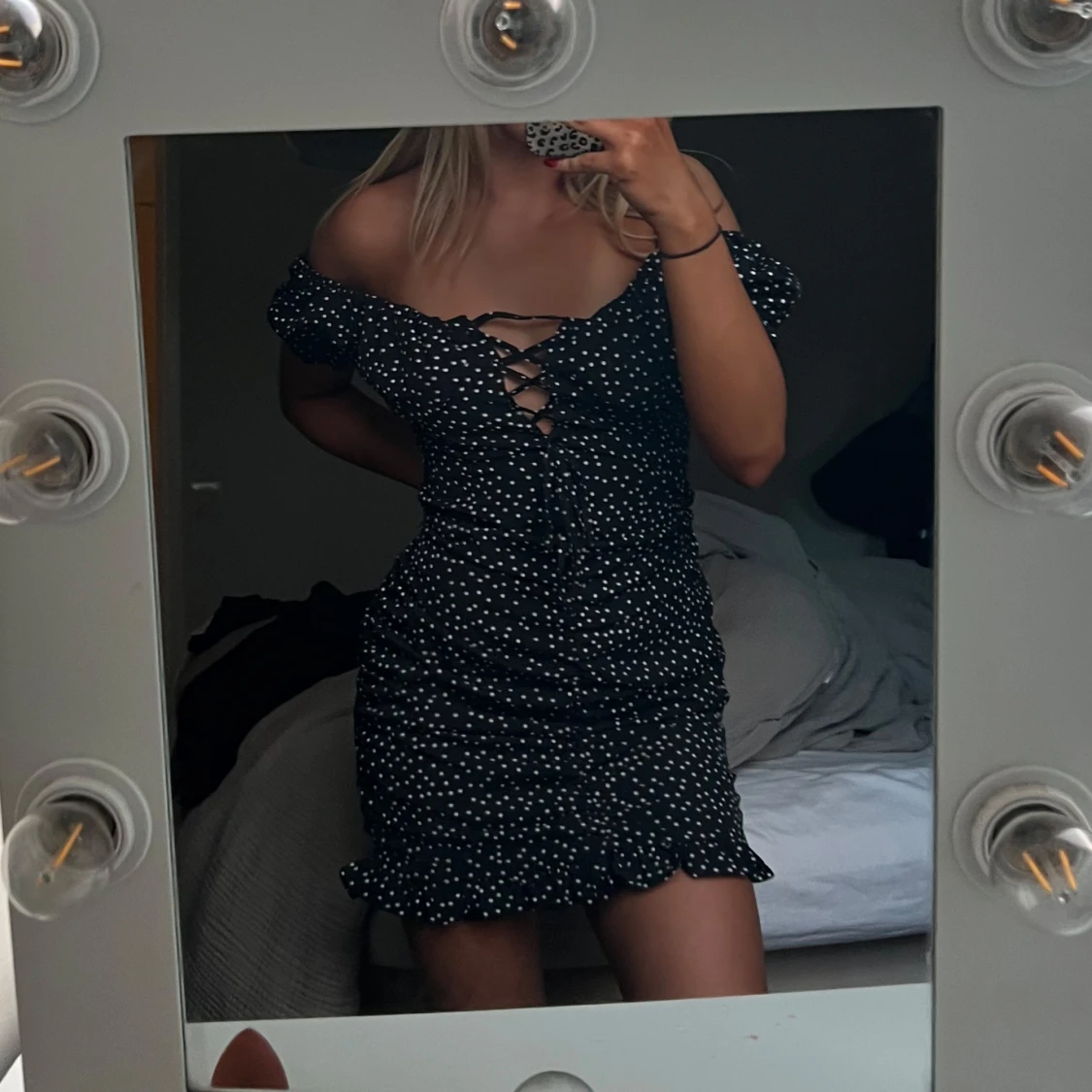 Svart kortklänning med vita prickar och snörning