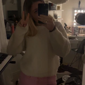 Vit stickad tröja - Mysig vit stickad tröja med rund hals och långa ärmar. Perfekt för kyligare dagar och enkel att matcha med olika outfits. Tröjan har en avslappnad passform och är ett måste i garderoben.