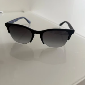 Svarta solglasögon från BOSS Orange - Snygga svarta solglasögon från BOSS Orange med klassisk wayfarer-inspirerad form. Glasögonen har mörka linser och kommer med originalfodral och putsduk som är oanvänd. Solglasögonen är använda max 2 gånger. Pris kan diskuteras:)