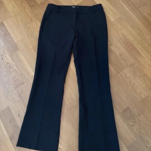 Svarta lågmidjade kostymbyxor Bik Bok - I modellen Vera petite, passar mig som är 161🤗Klassiska svarta kostymbyxor från Bik Bok med normal passform och bootcut-stil. Byxorna har hällor för bälte och diskreta fickor framtill. Perfekta för en stilren look.