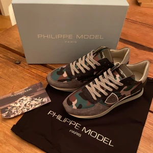 Philippe model skor - Säljer ett par snygga kamouflagefärgade sneakers i nästintill nyskick. De är sparsamt använda och mycket väl omhändertagna. Storlek 42, men passar dig som brukar ha 43 också. Jag är öppen för bud och kan tänka mig att gå ner i pris vid snabb affär. Skicka ett meddelande om du är intresserad!