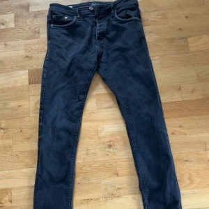 Svarta slim fit jeans från Jack & Jones - Svarta jeans från Jack & Jones i modellen Slim Fit Glenn. Klassisk femficksdesign, dragkedjegylf och smal passform. Perfekta för dig som gillar en stilren och enkel look.