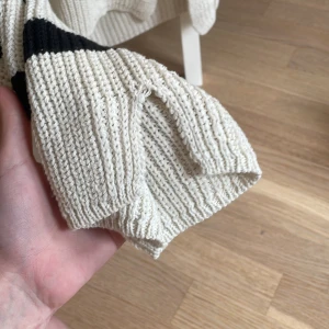 Randig stickad tröja från ONLY - Säljer en beige stickad tröja från ONLY med svarta horisontella ränder. Tröjan har lång ärm och är ribbstickad vilket ger en mysig och avslappnad look. Perfekt för lager-på-lager-stil!