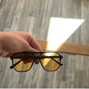 Tom Ford liknande - Snygga pilotinspirerade glasögon med svarta bågar och gula glas. Ramen är i metall och har en klassisk dubbelskena över näsan. Perfekta för dig som vill sticka ut med en retrovibe och cool look. Helt nya