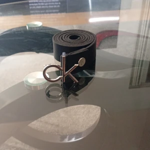 Svart skärp från Calvin Klein i skinn - Snyggt svart bälte från Calvin Klein i äkta skinn med stilren CK-logga i silver som spänne. Bältet är smalt och har tydlig Calvin Klein-text på insidan. Perfekt accessoar för att lyfta din outfit.