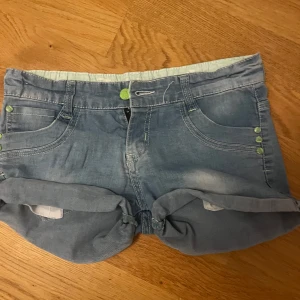 Blå lågmidjade jeansshorts från Shaily - Snygga blå jeansshorts från Shaily med uppvikta ben och snygga detaljer. Perfekta för varma dagar och enkel att matcha med allt.