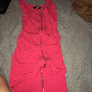 Rosa kort klänning från Bik Bok - Säljer en tight, ribbad rosa klänning från Bik Bok i storlek XS. Klänningen är ärmlös med smala axelband och har en dragkedja framtill som går hela vägen ner. Perfekt för dig som gillar en enkel men snygg look. Passar xs till M ! jätte stretchig 