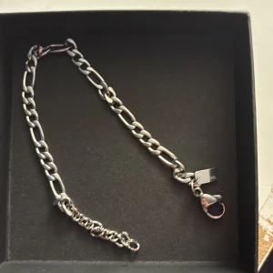 Silverfärgat armband från Arock - Kedjearmband i silverfärg från Arock med robusta, ovala länkar och karbinlås. Snyggt och stilrent smycke som passar perfekt till din streetstyle eller för att ge en extra edge till outfiten. Levereras i original ask.