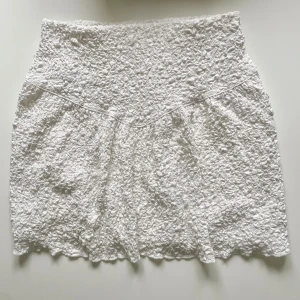 Vit kjol - Säljer en vit kort kjol med textur från Gina tricot i storlek xs. Använd en gång och därefter tvättad så lite urtvättad vit. Har resor i midjan och en underkjol. Köparen betalar frakten!