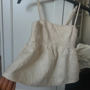 Söt topp - Säljer en beige topp som endast är andvänd ett par gånger. Den där lite längre där bak och kortare där fram