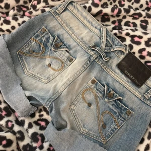 Lågmidjade shorts - Snygga ljusblå jeansshorts från Sisley med slitna detaljer och uppvikta ben. Supersnygga men jag har växt ur dom