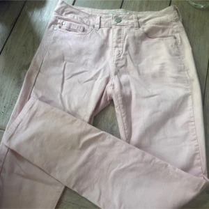 Ljusrosa jeansbyxor från Fransa - Snygga ljusrosa jeansbyxor från Fransa med klassisk femficksmodell och dragkedja. Byxorna är tillverkade i en mjuk bomullsblandning med polyester och lite stretch för extra komfort. Perfekta för dig som vill ha en fräsch och stilren look. Passar både S/M.