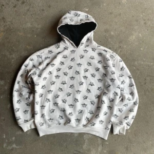 Vintage oversize Affliction Royal RAP Swag OG Skate hoodie - Vit hoodie från Royal med svart helprint av kronor och loggor. Tröjan har huva med svart insida och ribbade muddar vid ärmslut och nederkant. Perfekt för dig som gillar streetstyle och vill sticka ut med ett coolt mönster. Bra skick, allt syns på bilderna. Storlek L passar M. Längd: 63cm. Om du har några frågor är du välkommen att kontakta mig!