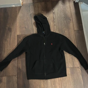 Ralph lauren zip - Säljer min svarta Ralph lauren hoodie i storlek 14-16 då den inte passar längre. Skriv om ni har frågor, skulle kunna tänka mig gå ner lite i pris