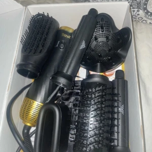 Svart och guld hårstylingkit TravX - Multifunktionellt hårstylingkit från TravX i svart och guld med flera utbytbara borsthuvuden och tillbehör. Perfekt för att skapa olika frisyrer.