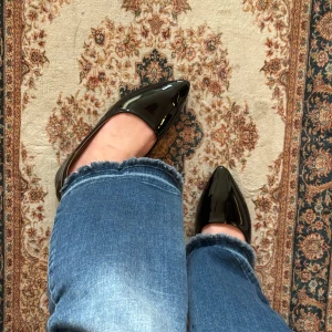 Svarta lackade ballerinaskor med spetsig tå - Snygga svarta ballerinaskor i glansigt lackmaterial med spetsig tå. Skorna har en klassisk och stilren design som passar till jeans eller kjol. Platt sula och bekväm innersula för vardagskomfort.