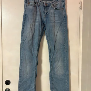Ljusblå jeans från Blend med detaljer - Snygga ljusblå jeans från Blend med raka ben och coola broderade bakfickor med nitar. Klassisk femficksmodell och knappgylf. Perfekta för dig som gillar jeans med lite extra detaljer och en avslappnad vibe.
