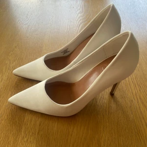 Vita stiletto klackskor - Satin 10 cm klackskor. Helt nya, endast prövade (kommer i lådan jag köpte de i). Säljer pga de var för små (säljer även likadana i st 40). De är små i storleken. 