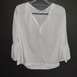 Vit blus  - Säljer en vit blus från Notion 1.3  i storlek M. Blusen har långa ärmar och v-ringad. Perfekt för en stilren och feminin look.