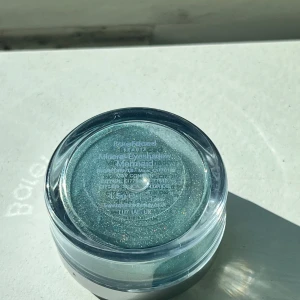 Mineralögonskugga Mermaid - Säljer en lös mineralögonskugga i nyansen Mermaid. Färgen är skimrande turkos med inslag av glitter, perfekt för att skapa en färgstark look. Kommer i en rund plastburk med skruvlock.