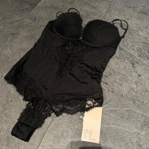 Svart spetsbody med bygel och vadderade kupor - Säljer en oanvänd spetsbody i strl 36🖤 Bodyn har hakknäppning bak och push up