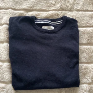 Svart tröja från Pier One - En stilren mörkblå tröja från Pier One med rund halsringning och ribbade muddar. Perfekt för lager-på-lager och enkel att matcha med olika outfits. Klassisk passform och mjukt material.