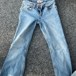 Ljusblå bootcut jeans från 157 - Ljusblå jeans från 157 i modellen Low Boot. Byxorna har klassisk femficksdesign, dragkedja och knapp framtill samt bootcut-ben. Perfekta för dig som gillar en tidlös jeanslook med lite utsvängda ben.