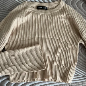 Kort Beige ribbad tröja från SHEIN - Säljer en beige ribbad tröja från SHEIN med rund halsringning och långa utsvängda ärmar. Enkel och stilren design som passar till mycket.